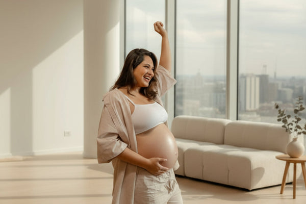 Pregnant woman standing in a modern living room with large windows